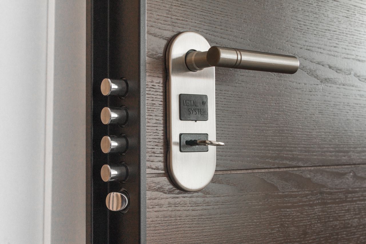 Services Metal door handle and lock system with key inserted, showcasing security features.